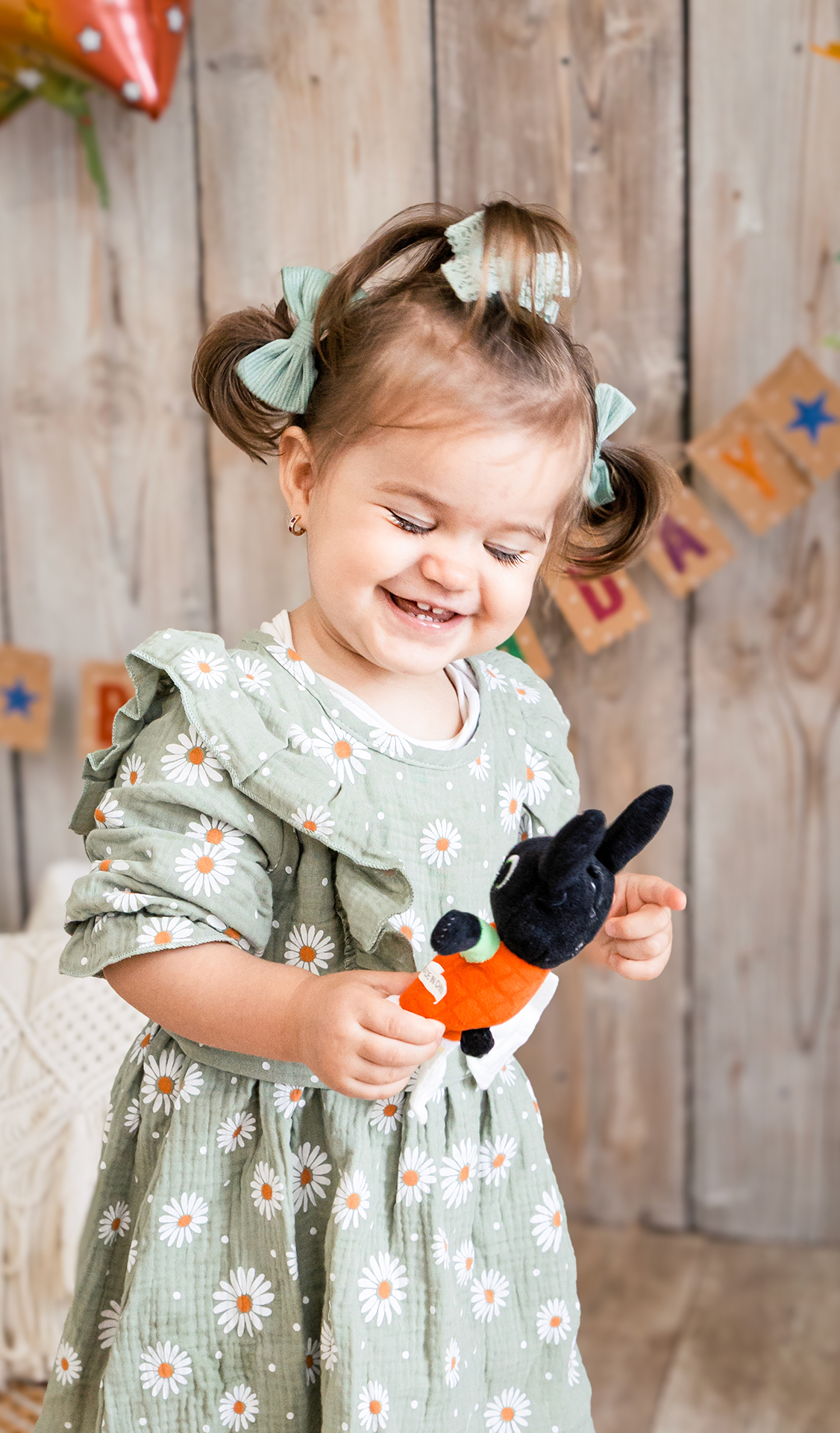 tündéri portréfotó egy csodaszép kislányról aki becsukott szemmel nevet a képen