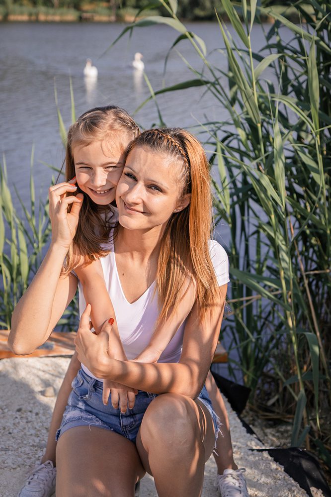Tőzegtó partján anya-lánya jelenet, háttérben hattyúkkal.