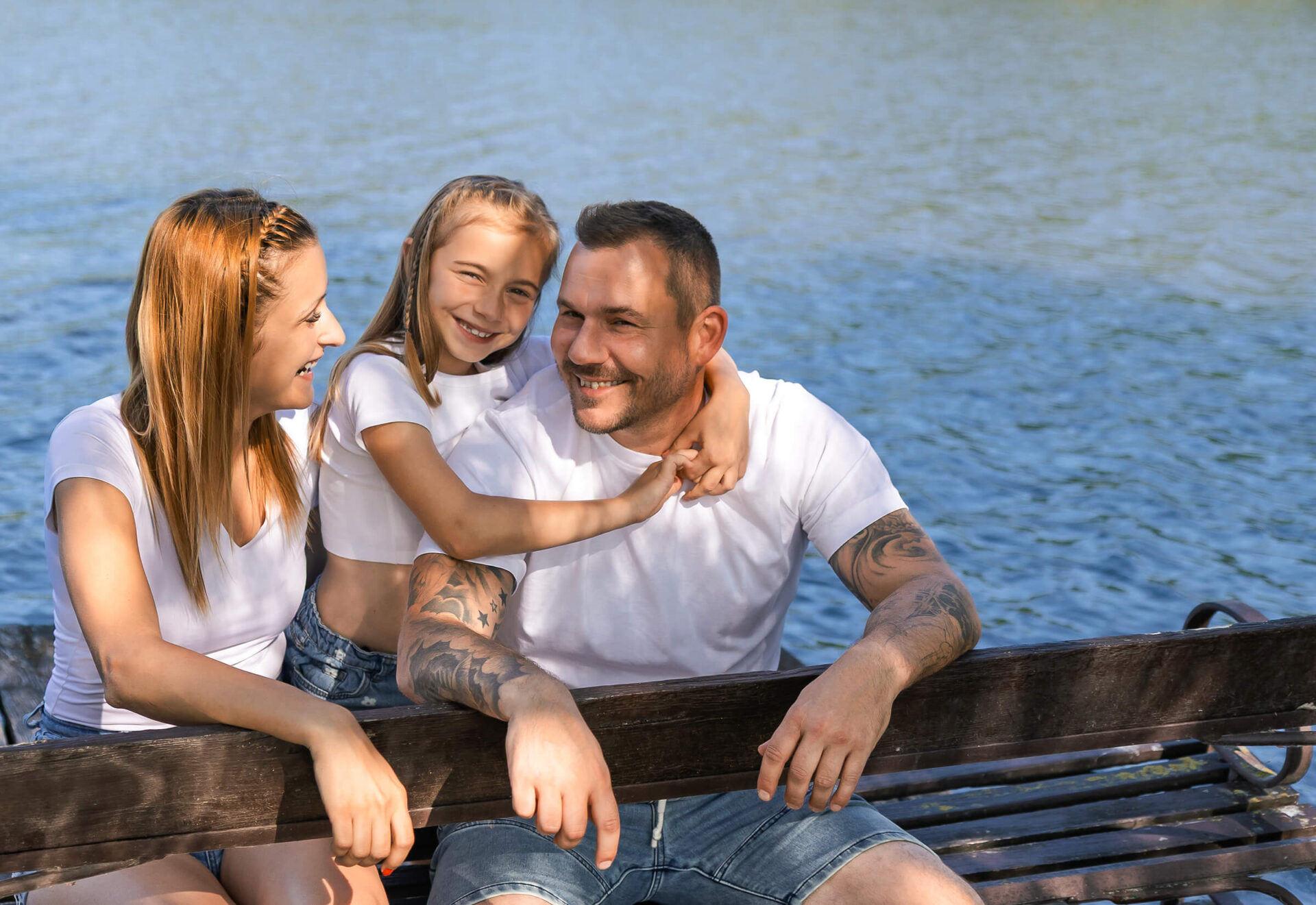 Családi, lifestyle pillanatok egy tóparti fotózáson, ahol tükröződik a családon a jókedv és a játékosság.