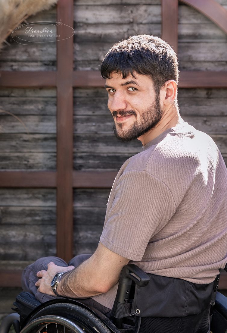Lifestyle férfi portré, egy kerekesszékes fiatalemberről, természetközeli helyszínen